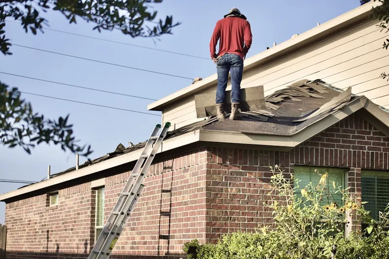 Professional roofer working on a residential roof in Yellow Pine